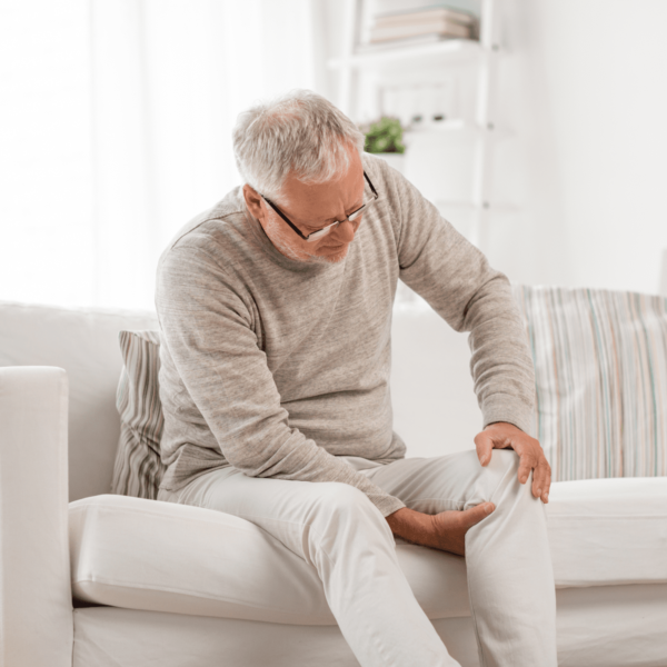 older man with knew pain on couch