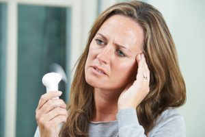 woman overheated with hand fan