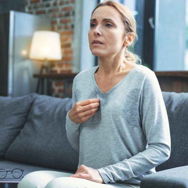 woman sitting on a couch with a laptop and a book