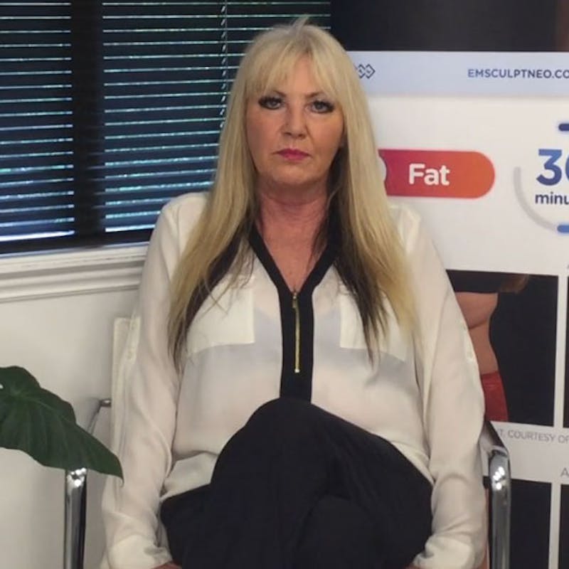 screen shot of blond woman sitting in chair