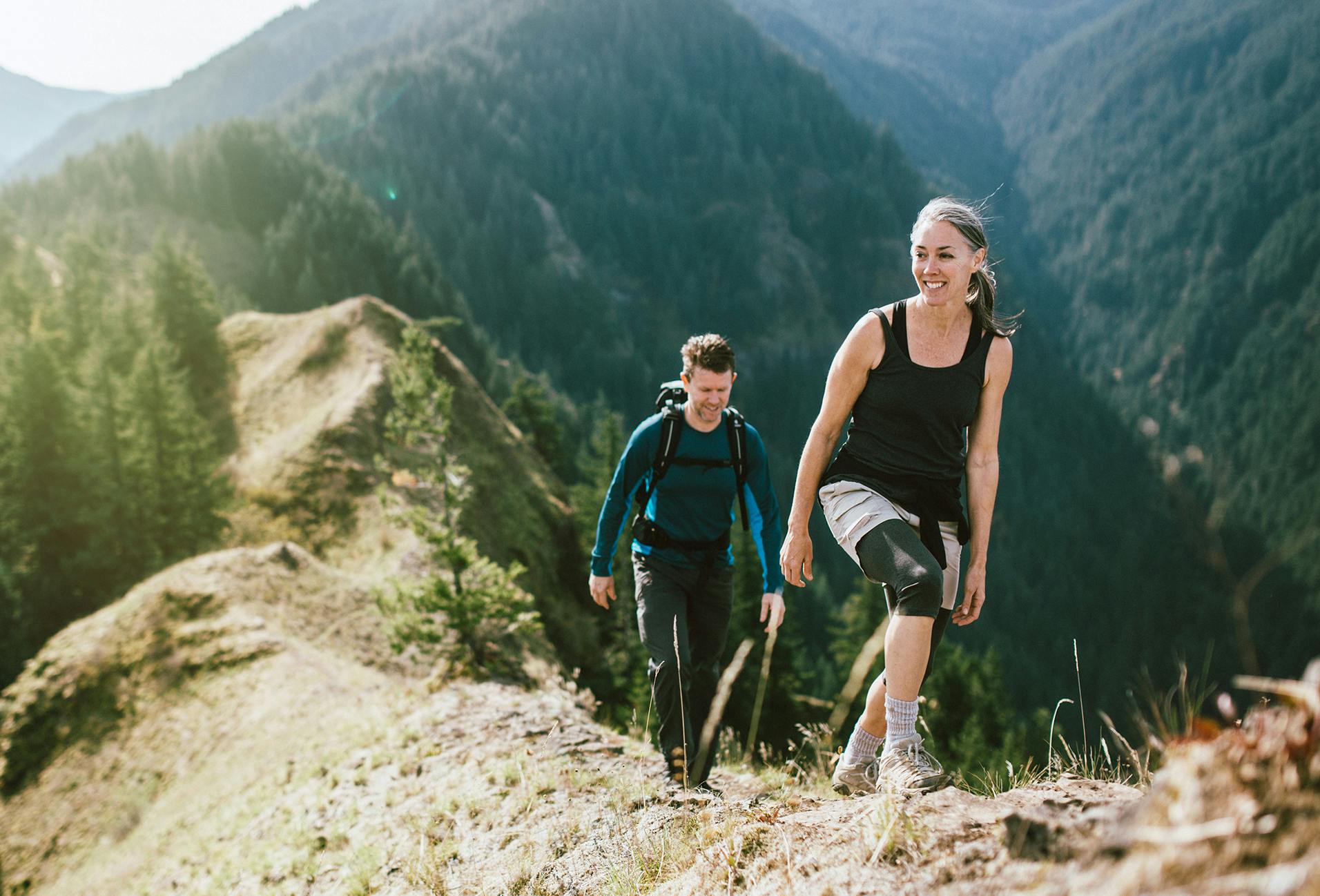 there are two people hiking up a mountain side with a backpack