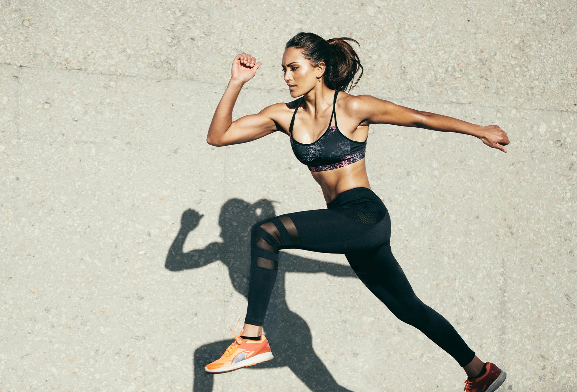 woman in black sports bra top and leggings running