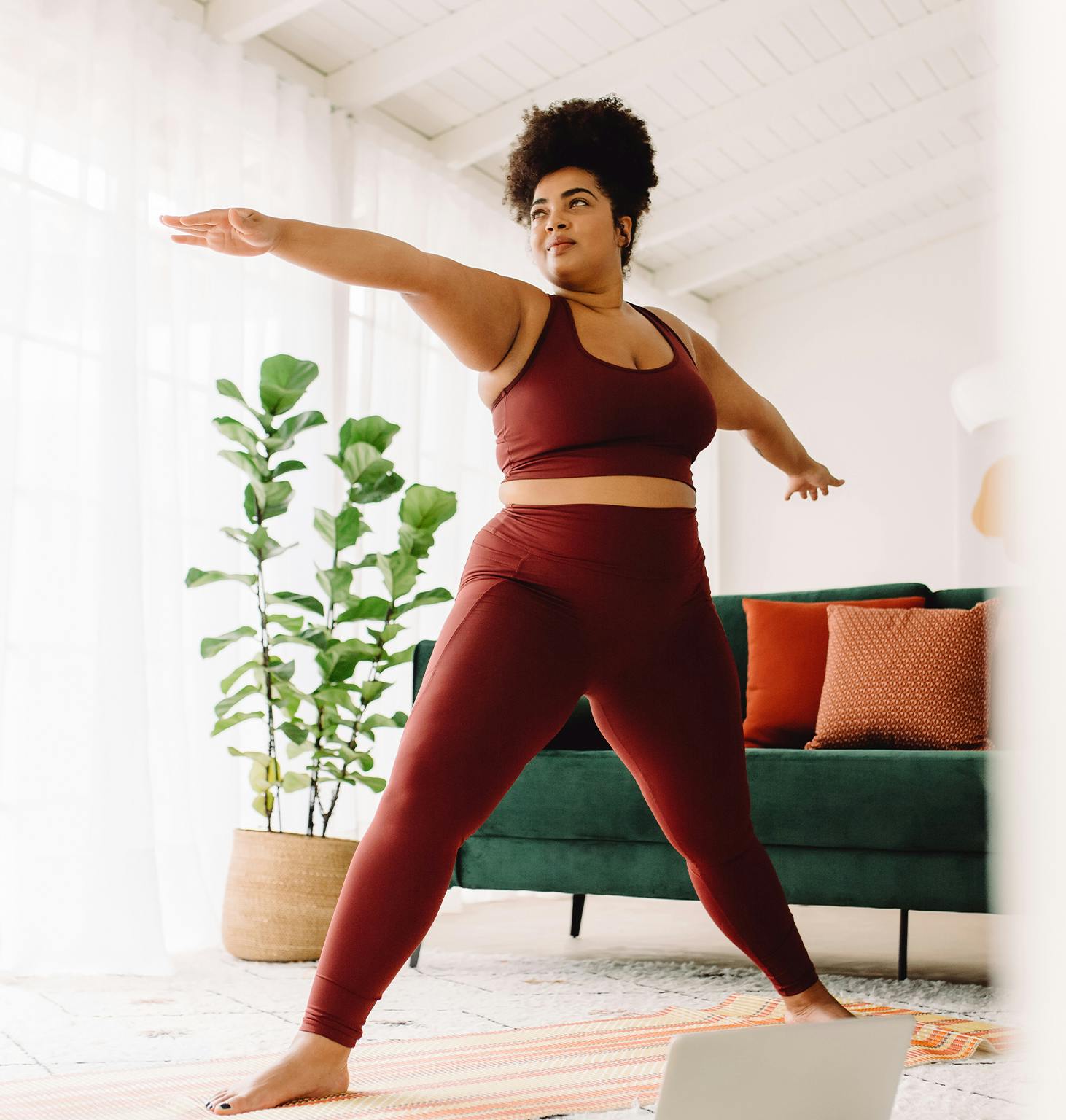 there is a woman in a red outfit doing yoga on a laptop