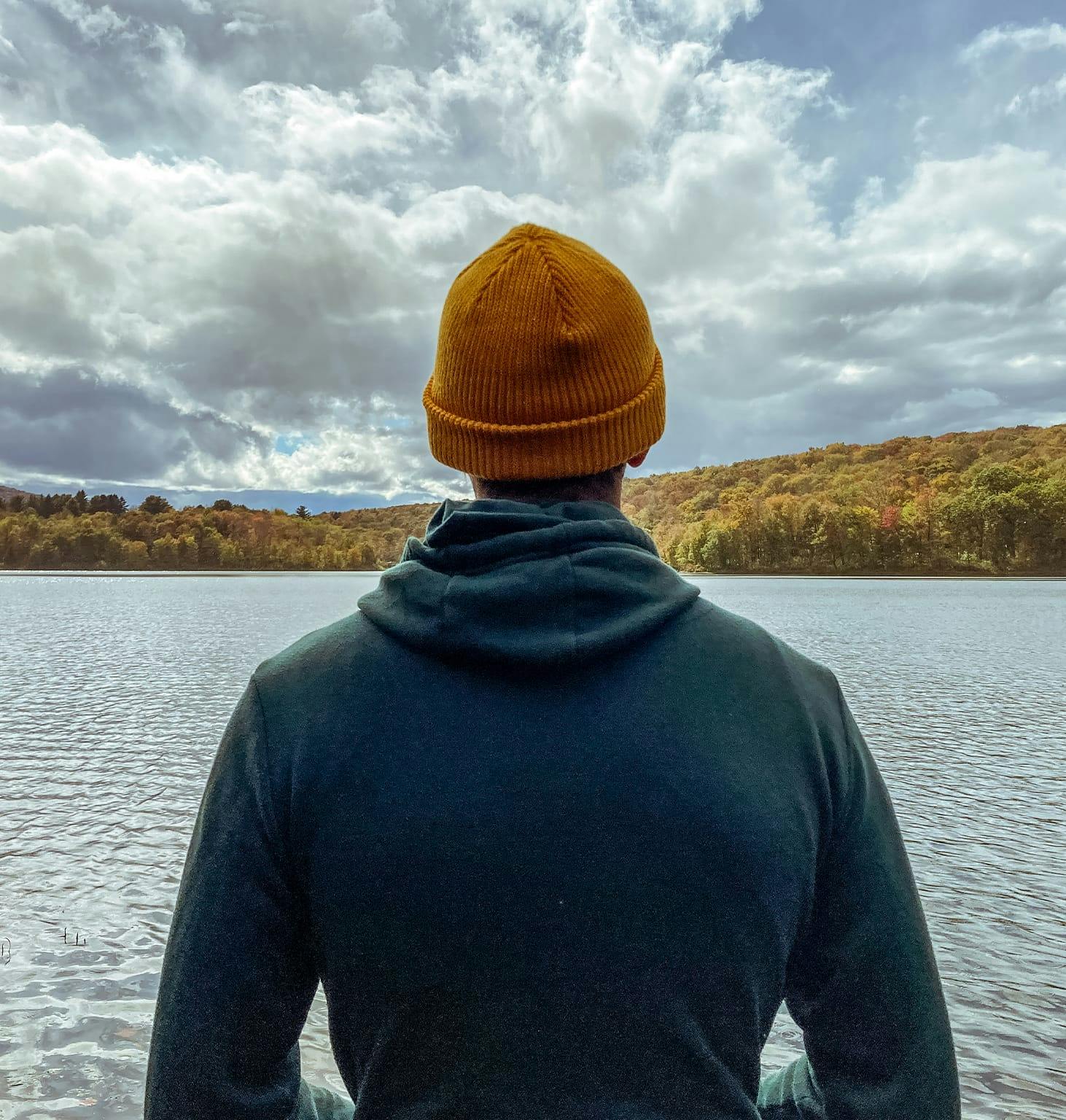 man in a yellow hat looking out over a lake