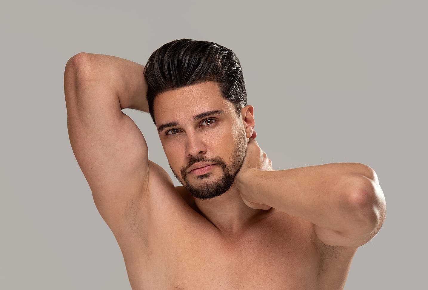 man with brunette hair topless with his hair neatly done
