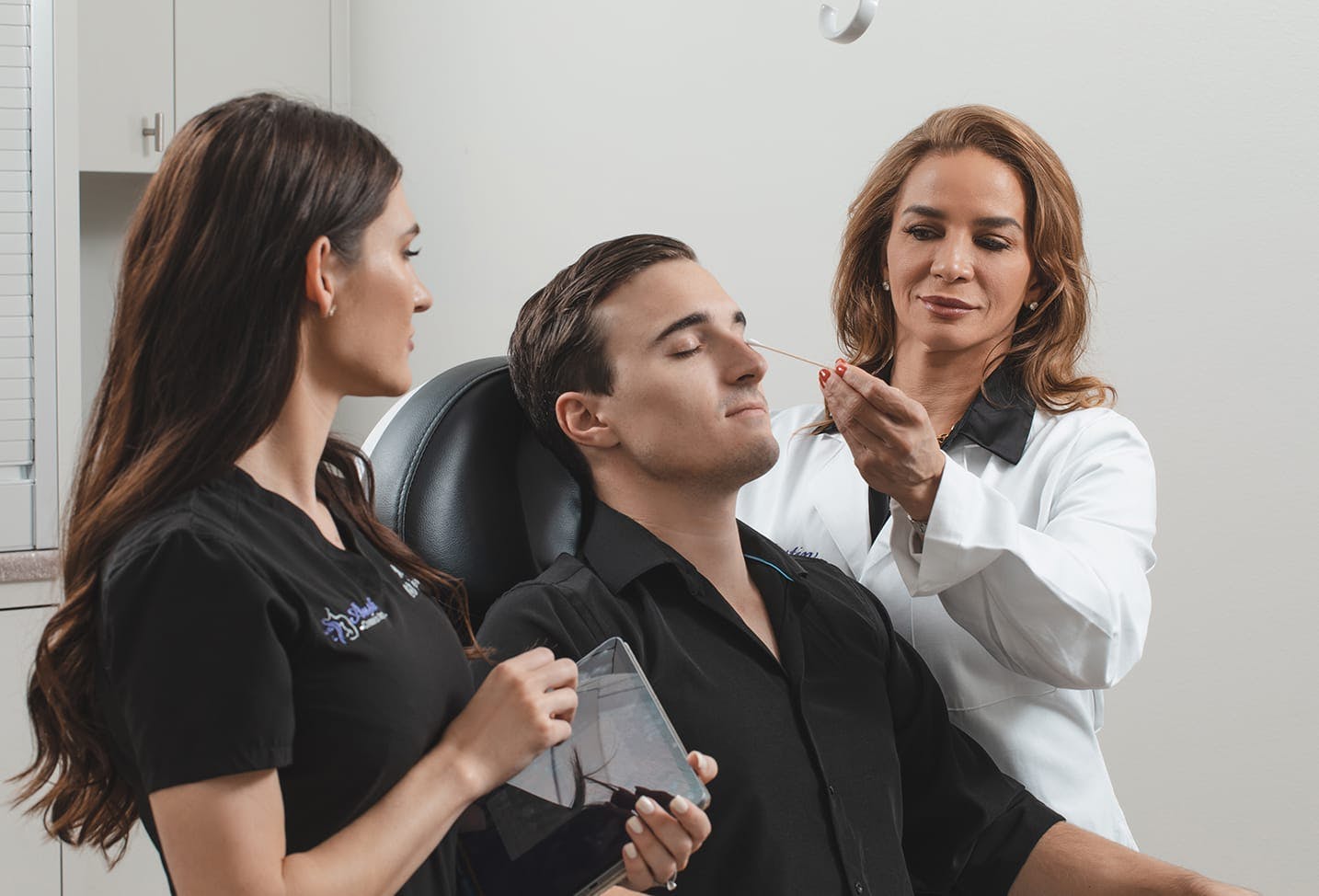 Dr. Cabret and a RN doing a facial consultation on a male patient