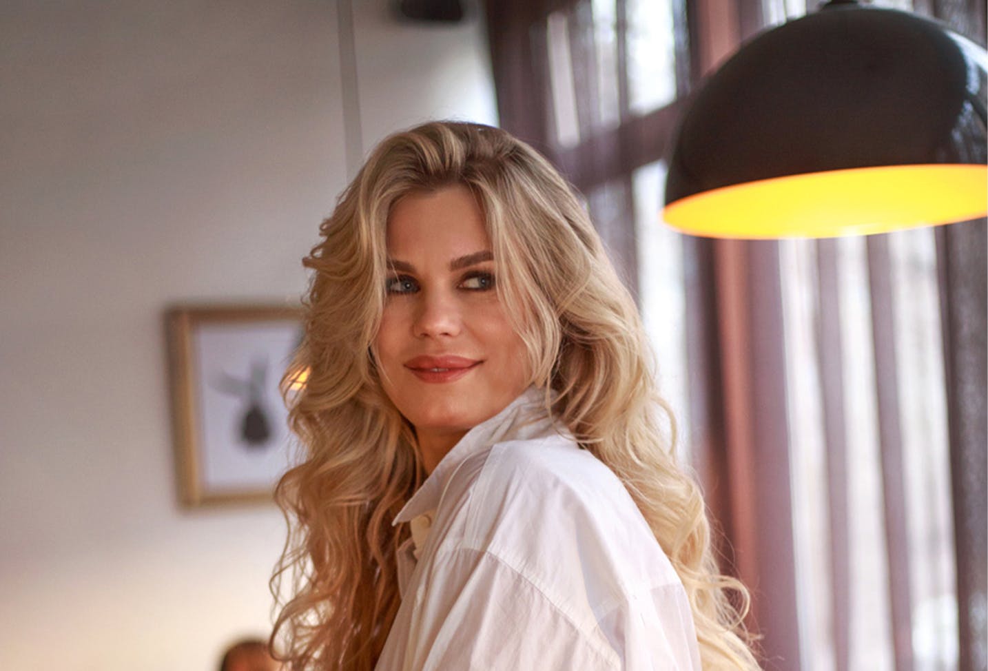 a female model with long blonde hair in a white button down