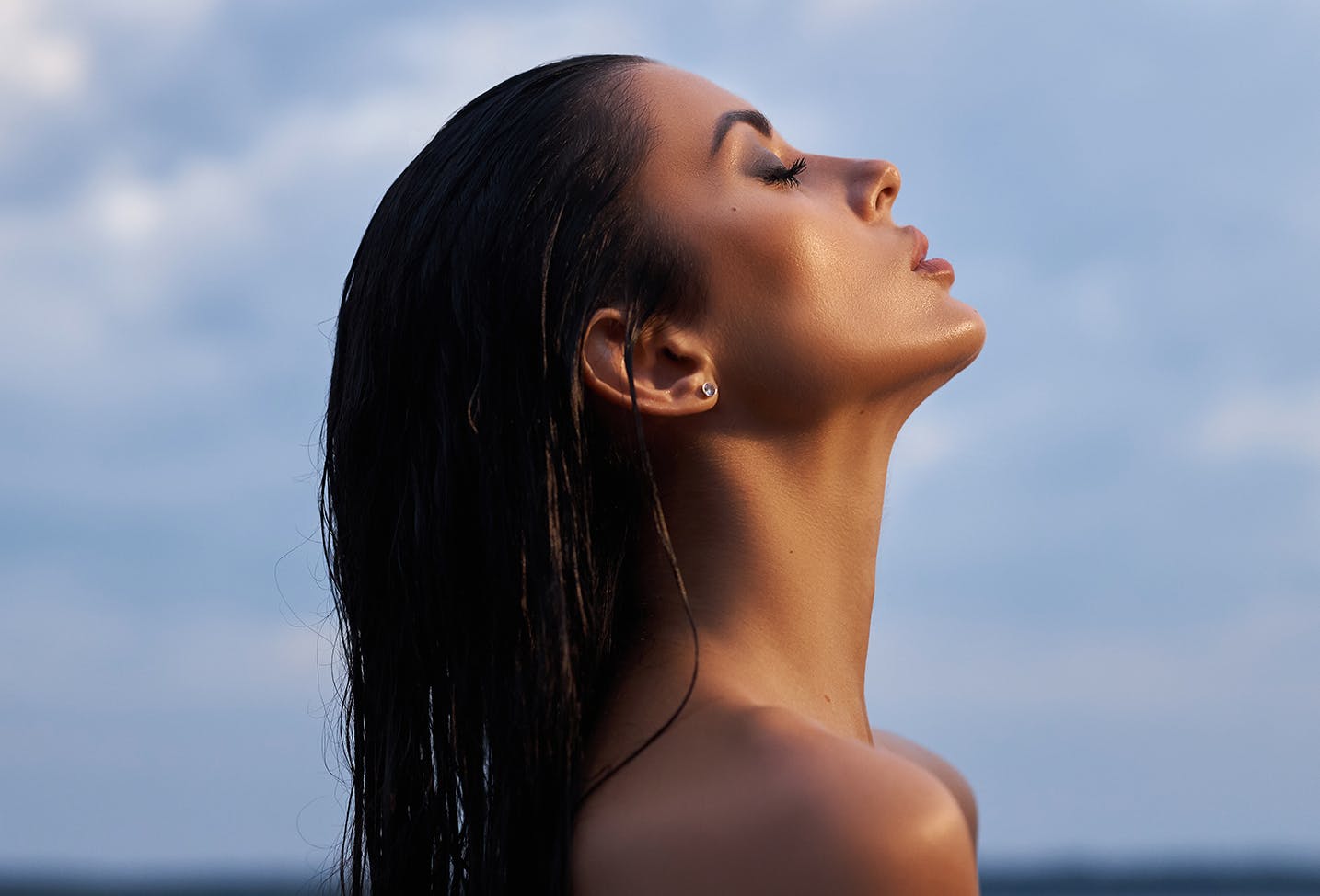 a close up of a woman with long wet brunette hair