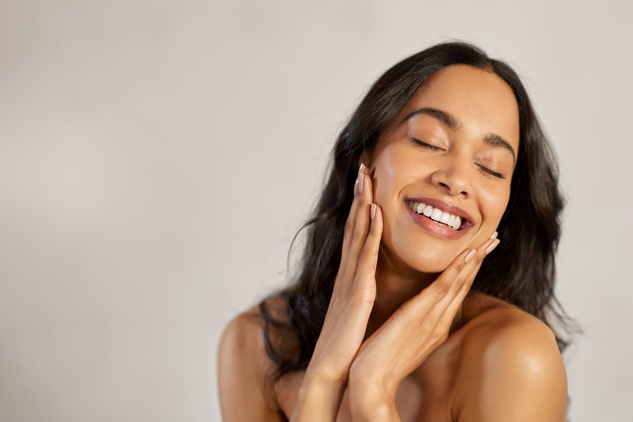 Woman smiling and holding face