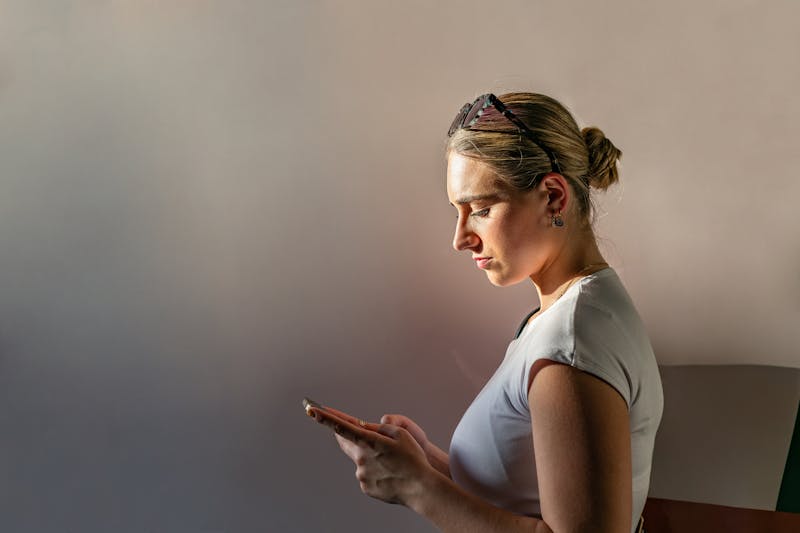 woman looking down at her phone