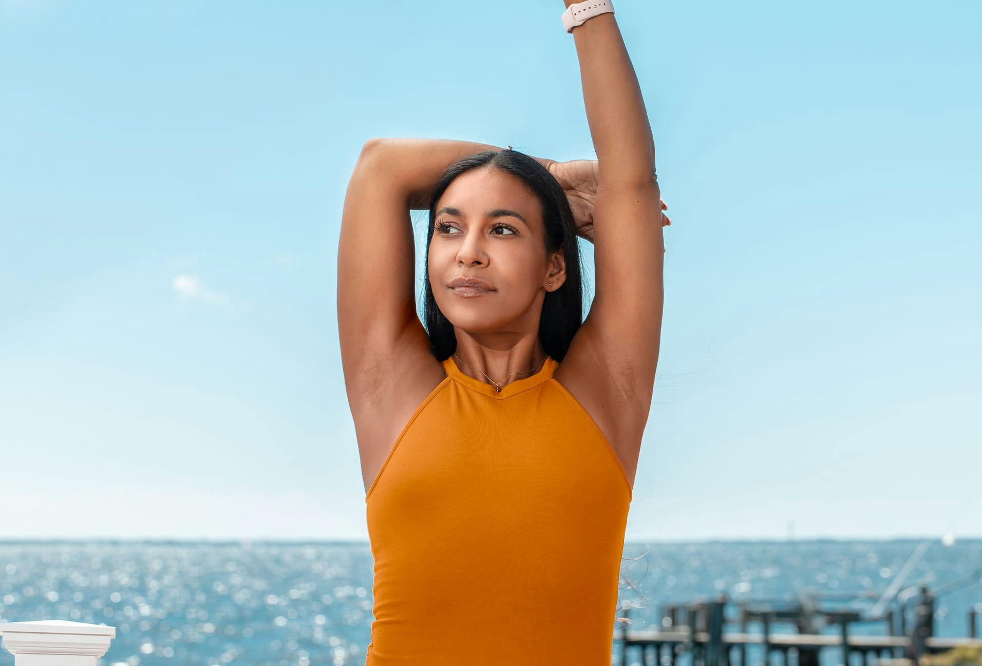 Woman in orange blouse with arms in air