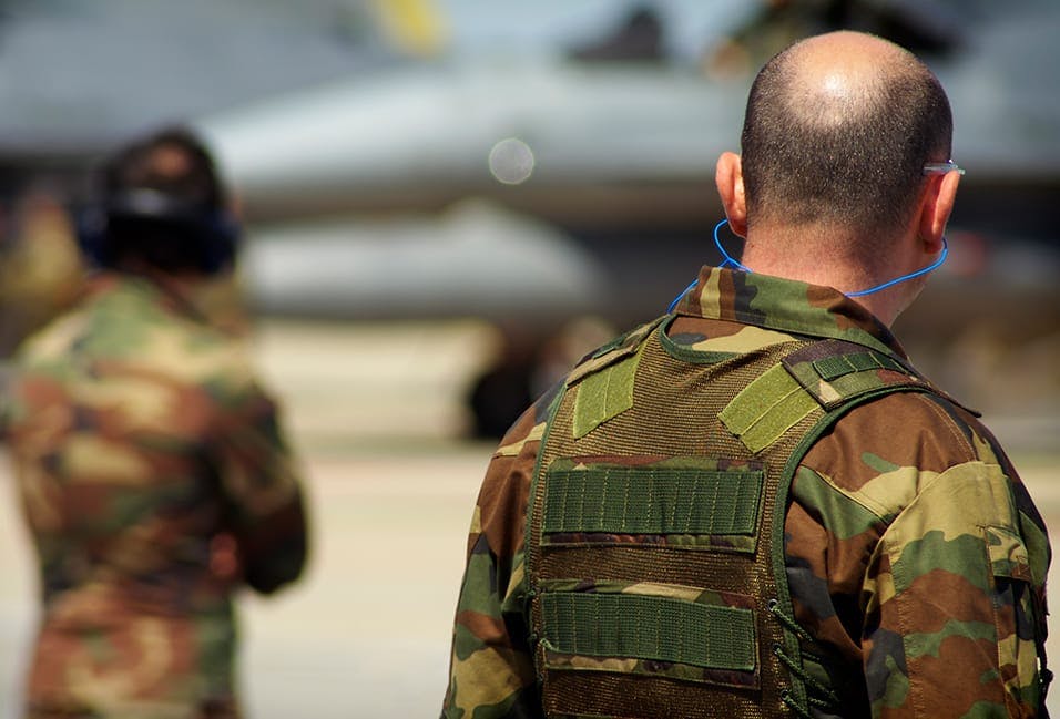 Man in military uniform wearing earplugs
