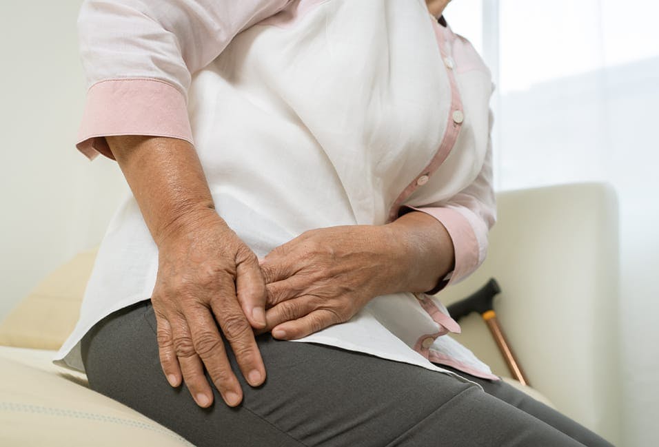 Person holding their hip in pain