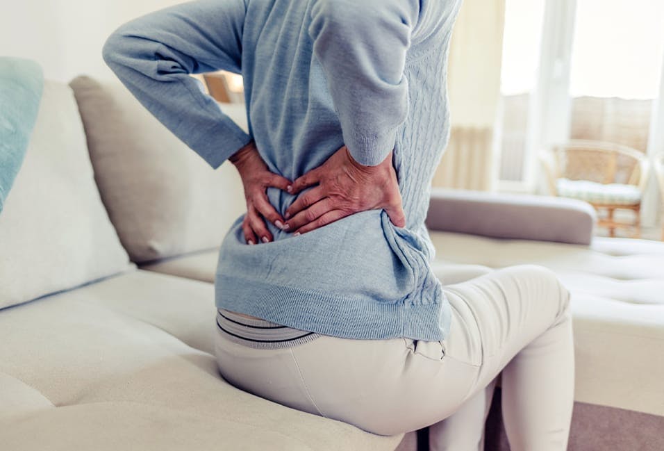 Woman holding her back in pain