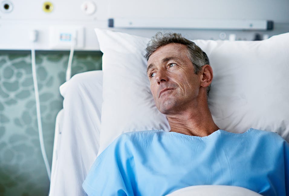 Man lying down in hospital bed