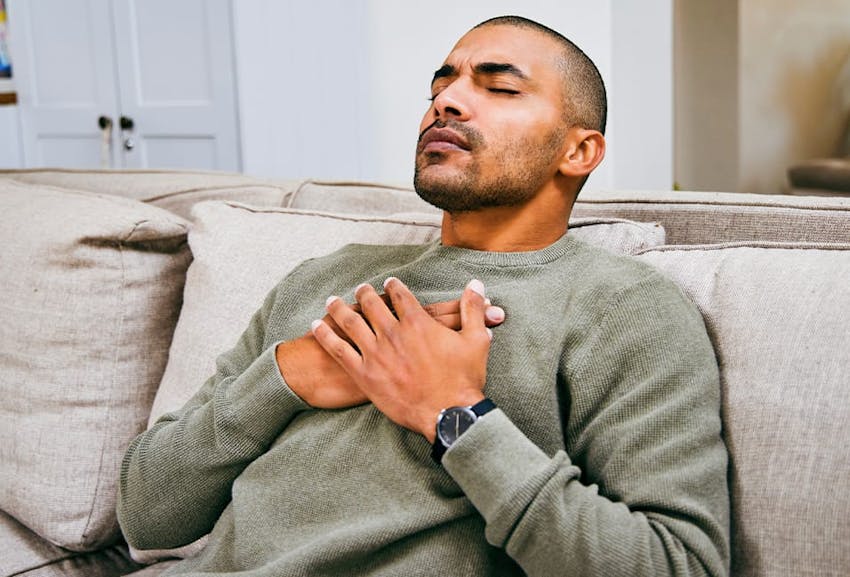 Man holding his chest in discomfort