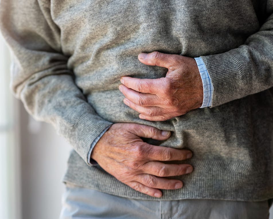 Older person holding stomach in pain