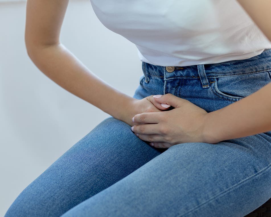 Woman holding her lower abdomen in discomfort