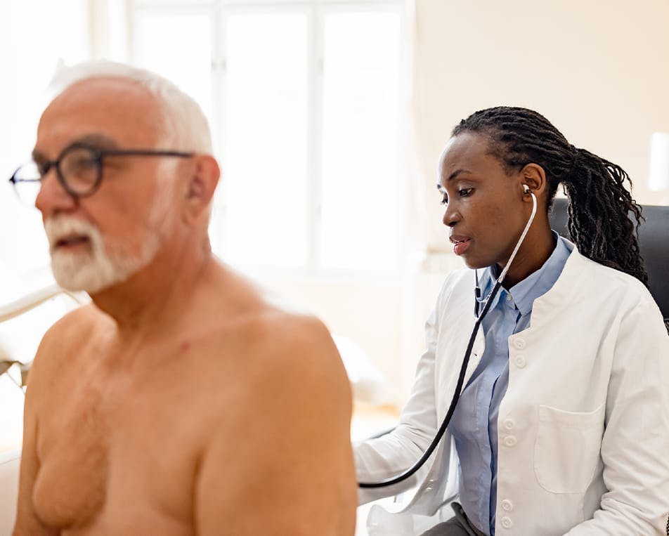 Doctor checking man's lungs with stethoscope