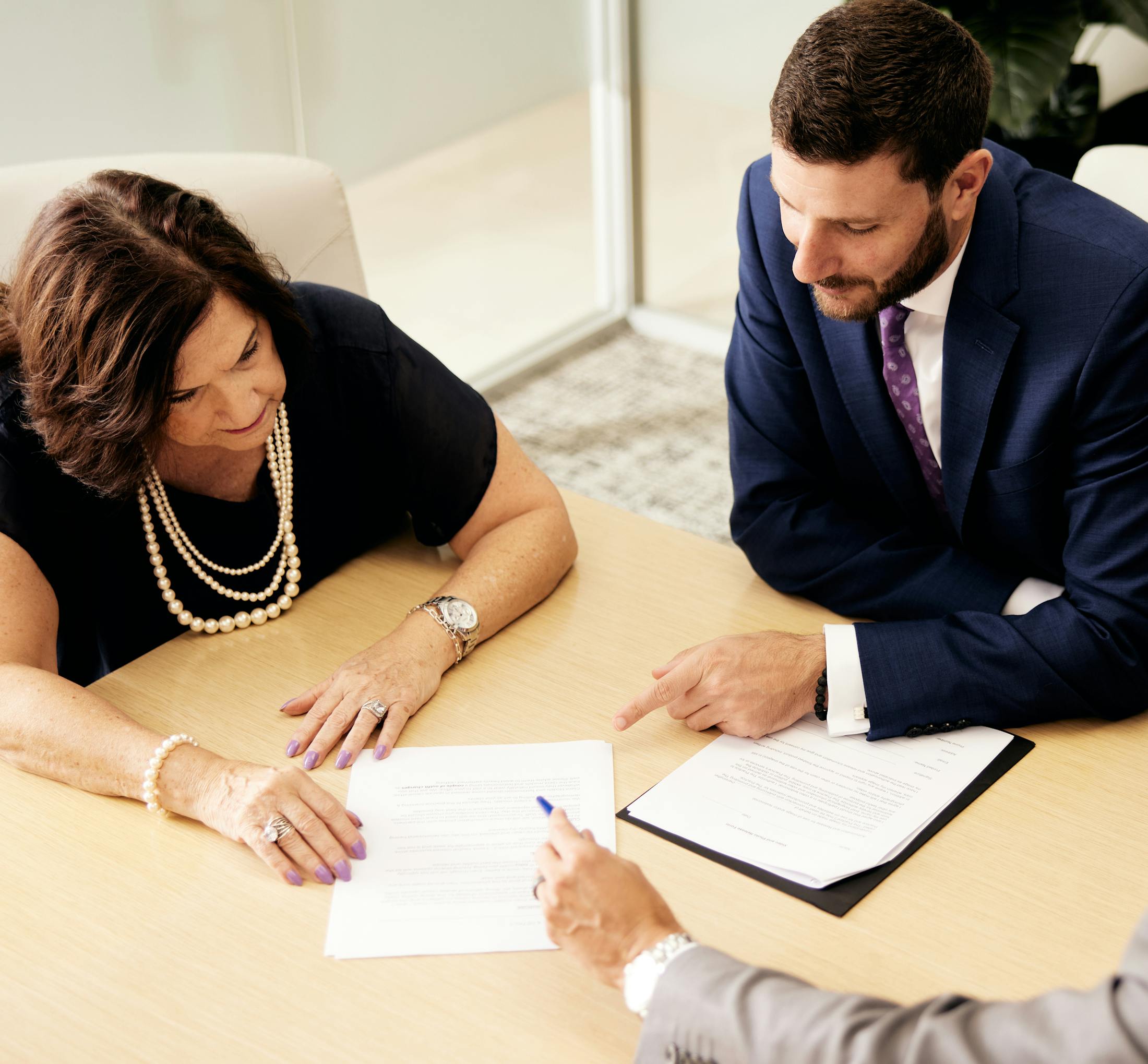 Woman sitting down with a couple of attorneys