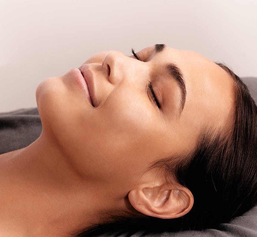 Woman Smiling Laying Down About to Receive Treatment