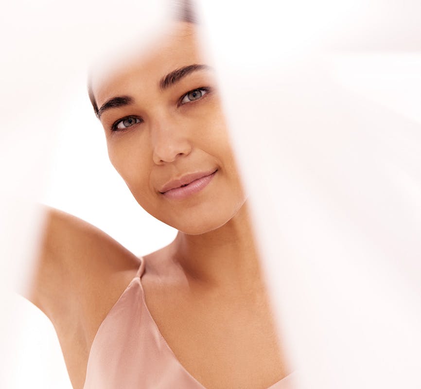 Woman Looking at Photo Through Flowing Curtains