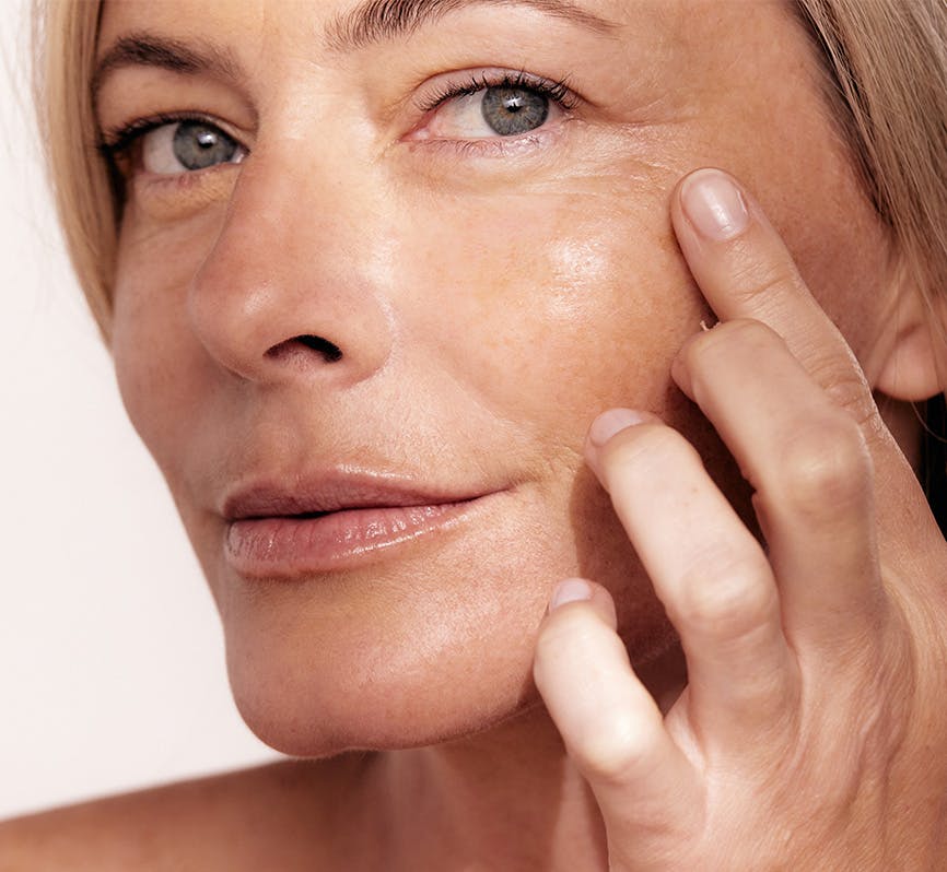 Woman pointing to wrinkles - signs of aging