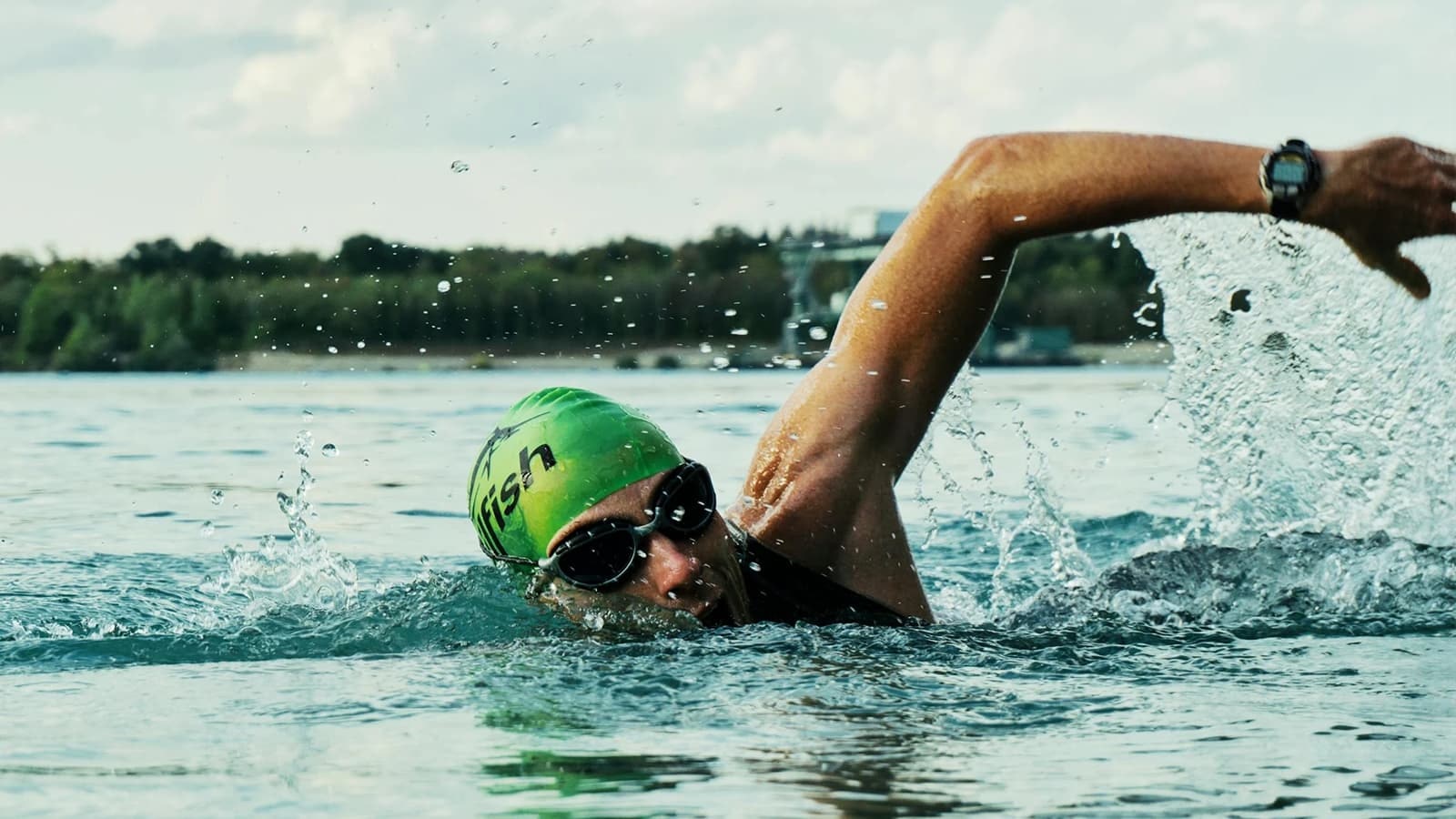 Die Grundlagen und Vorteile von Ausdauertraining. Bild mit einem Mann, der Ausdauertraining betreibt, indem er schwimmen geht.
