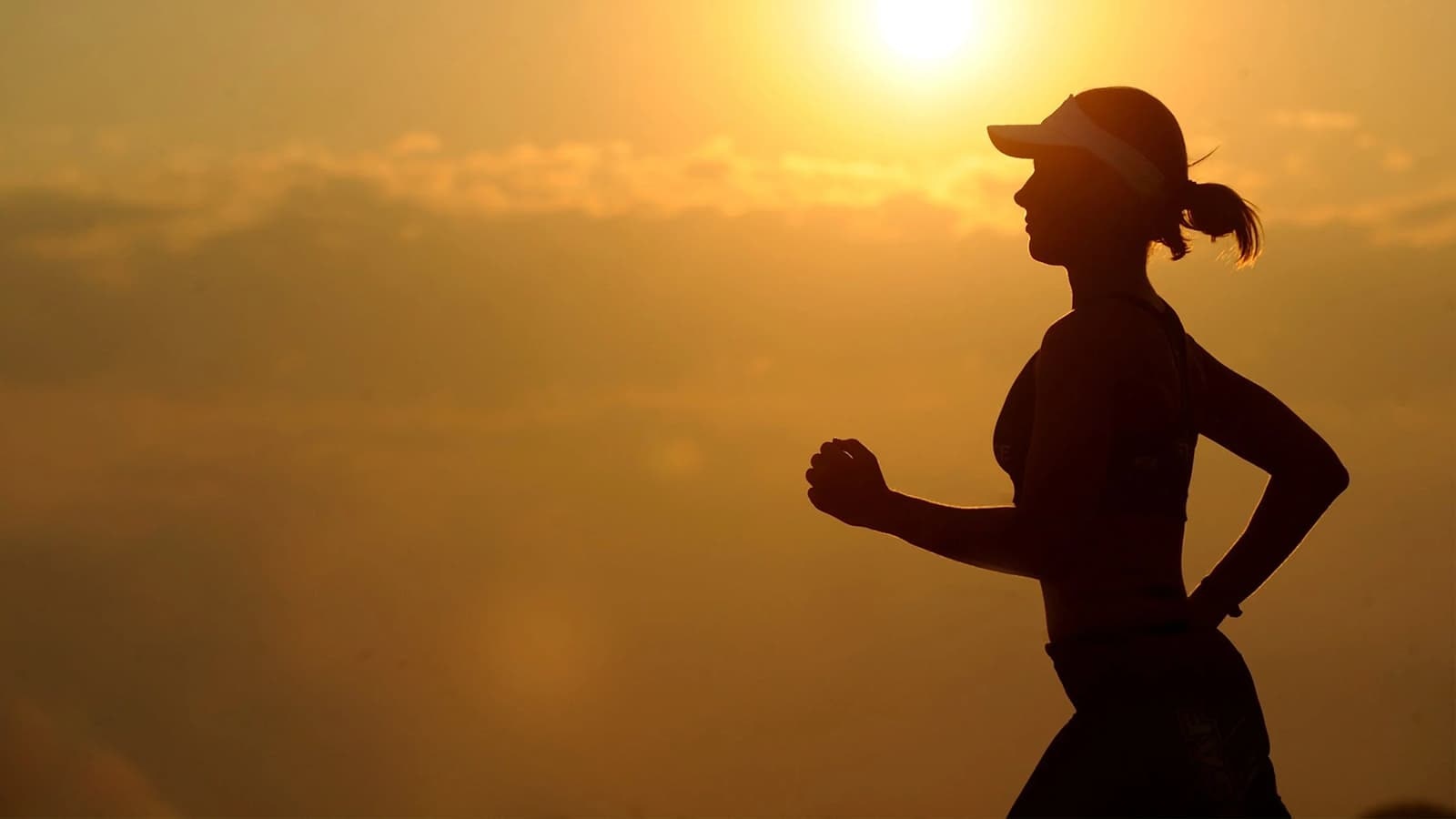 Die Grundlagen und Vorteile von Ausdauertraining. Bild mit einer Frau, die Ausdauertraining betreibt, indem sie laufen geht.