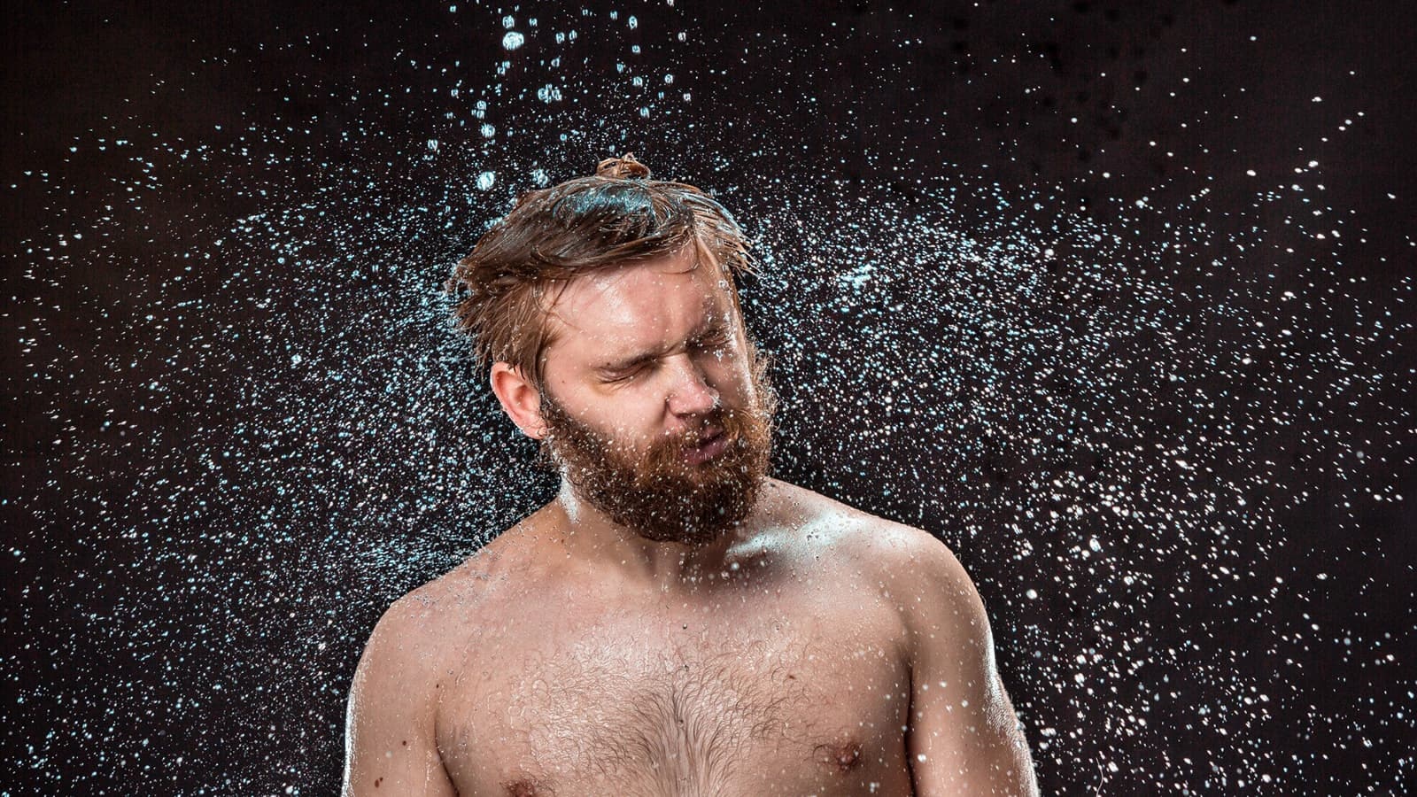 Kalt duschen nach dem Sport. Bild von einem Mann, den das kalt Duschen zum schütteln bringt.