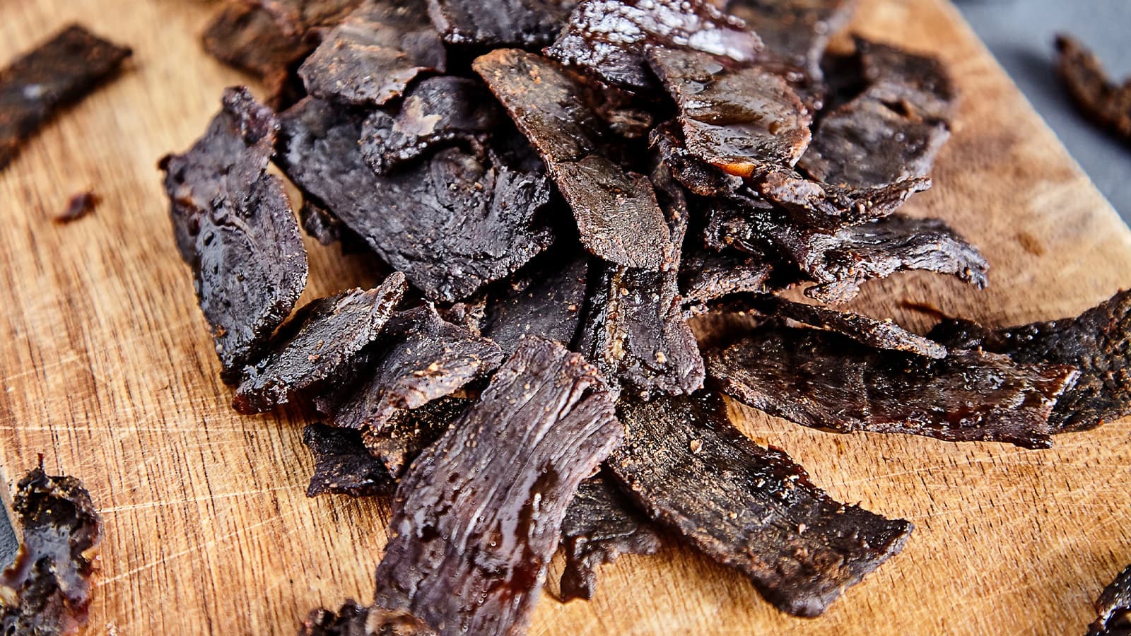 Wie gesund ist Beef Jerky? Bild von Beef Jerky auf einem Holzbrett.