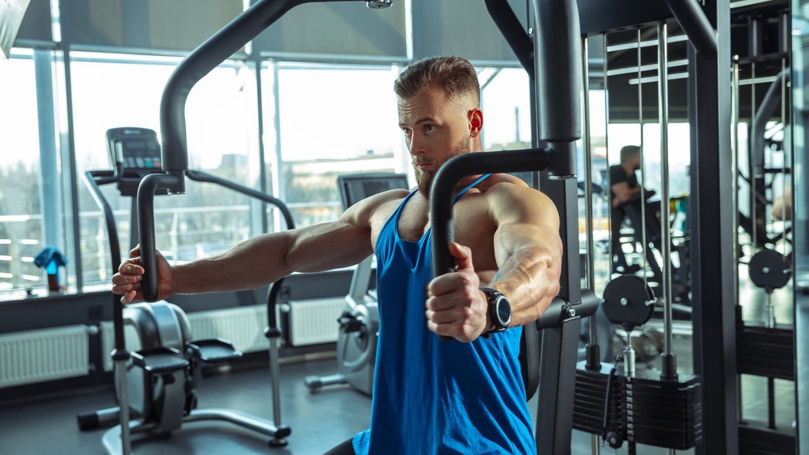 Die besten Brustübungen. Bild von einem Mann, der Brustübungen mit einem Fitnessgerät durchführt.