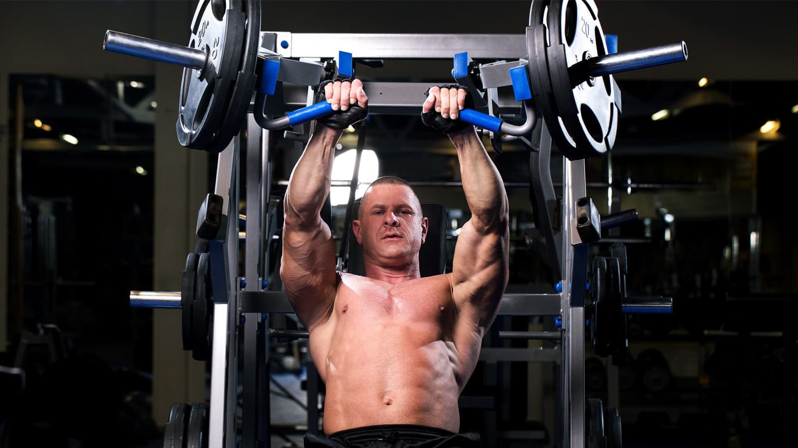 Die besten Brustübungen. Bild von einem Mann, der Brustübungen mit einem Fitnessgerät durchführt.