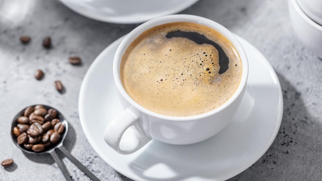 Wie gesund ist Koffein? Bild von einem Kaffee und Kaffeebohnen, in denen Koffein enthalten ist.