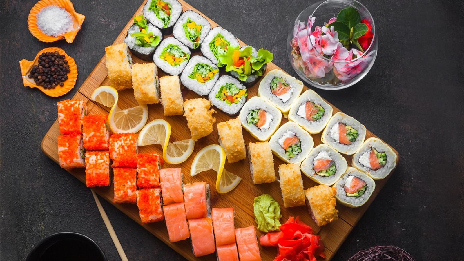 Wie gesund ist Sushi wirklich? Bild von Sushi und anderen Zutaten auf einem Holzbrett.