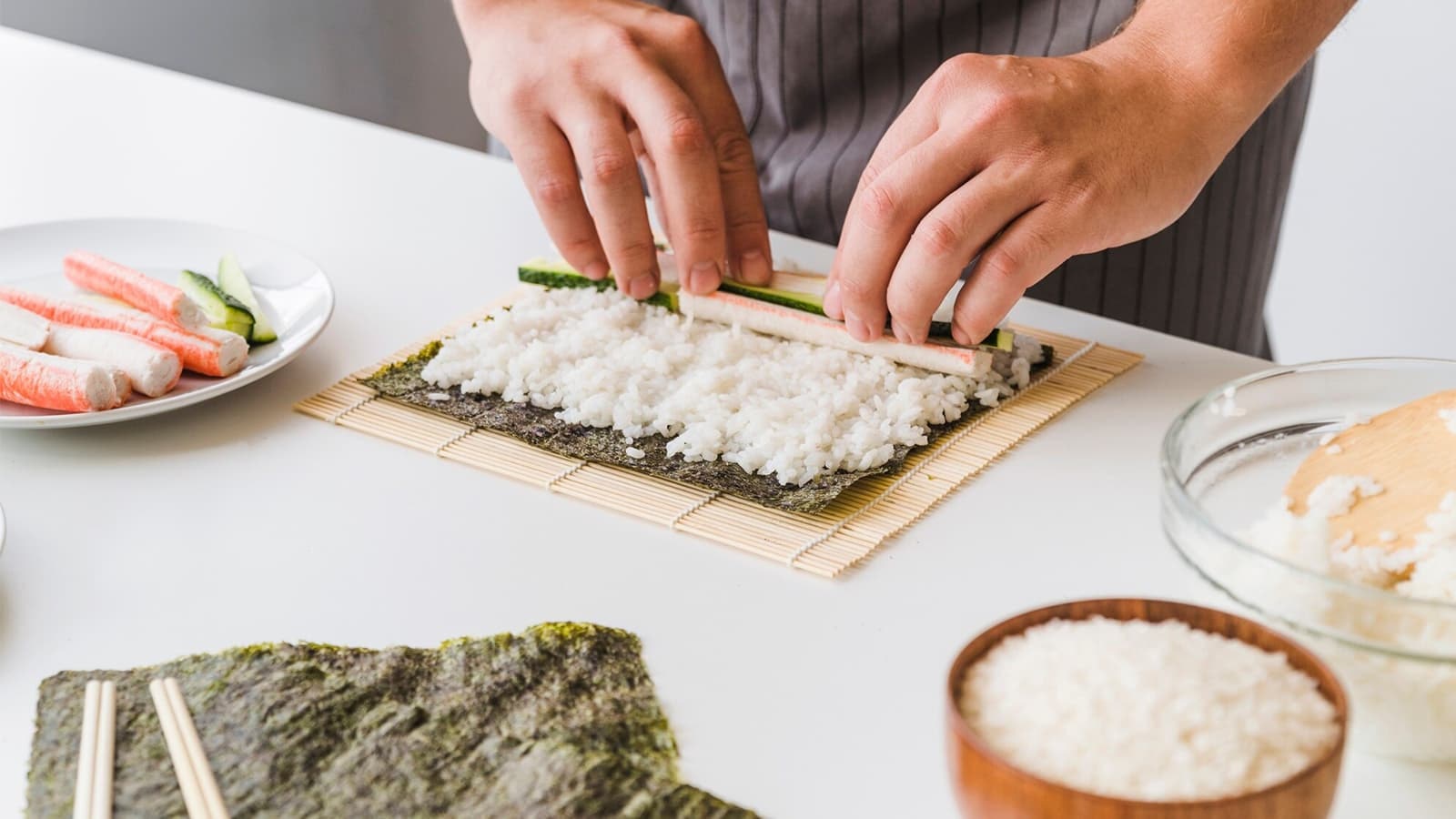 Sushi einfach selbst machen. Bild von einer Küchenplatte, auf der grade Sushi zubereitet wird.