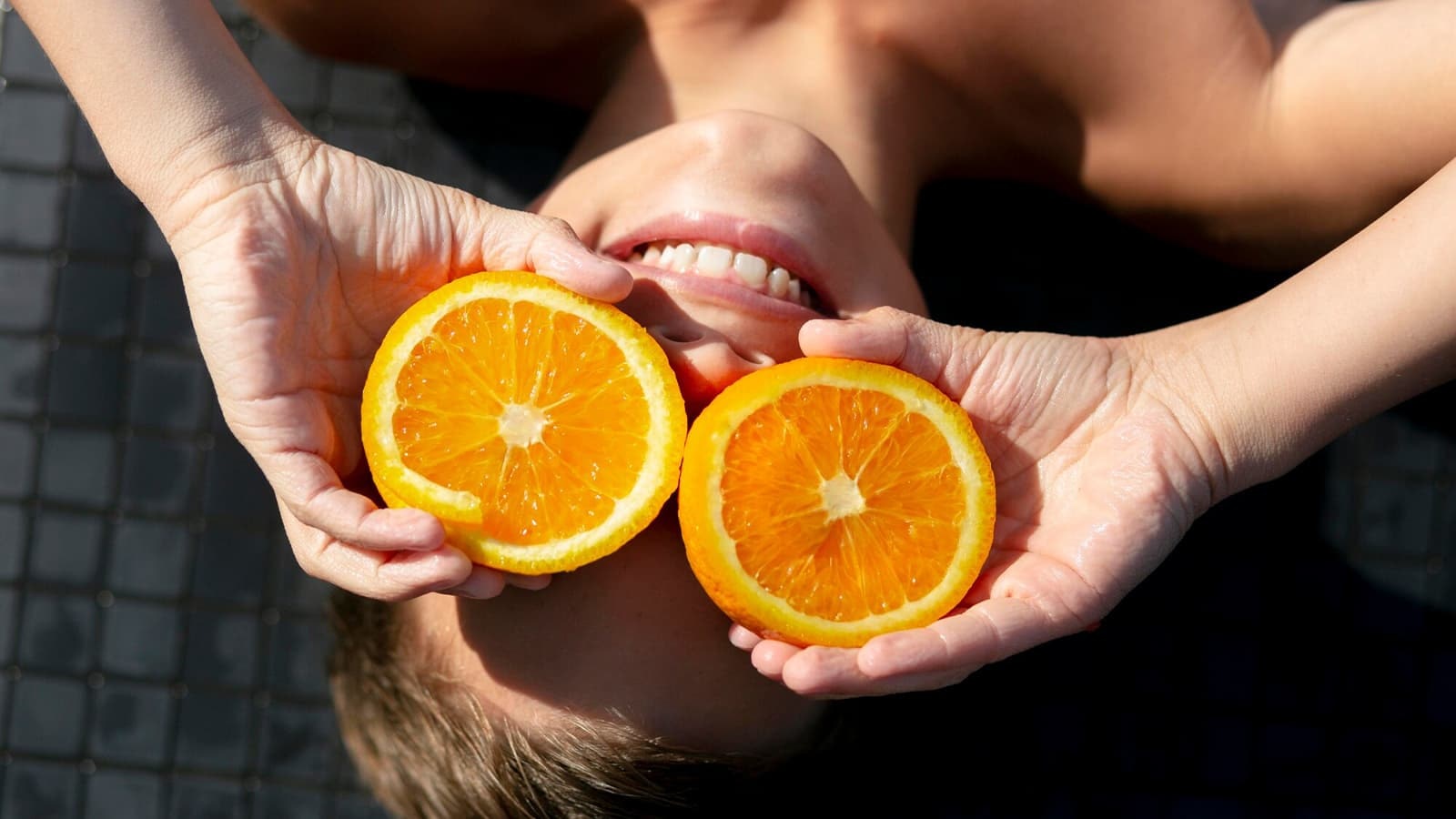 Wofür braucht man Vitamin C? Bild von einem Jungen, der Orangen hält, welche reichhaltig an Vitamin C sind.