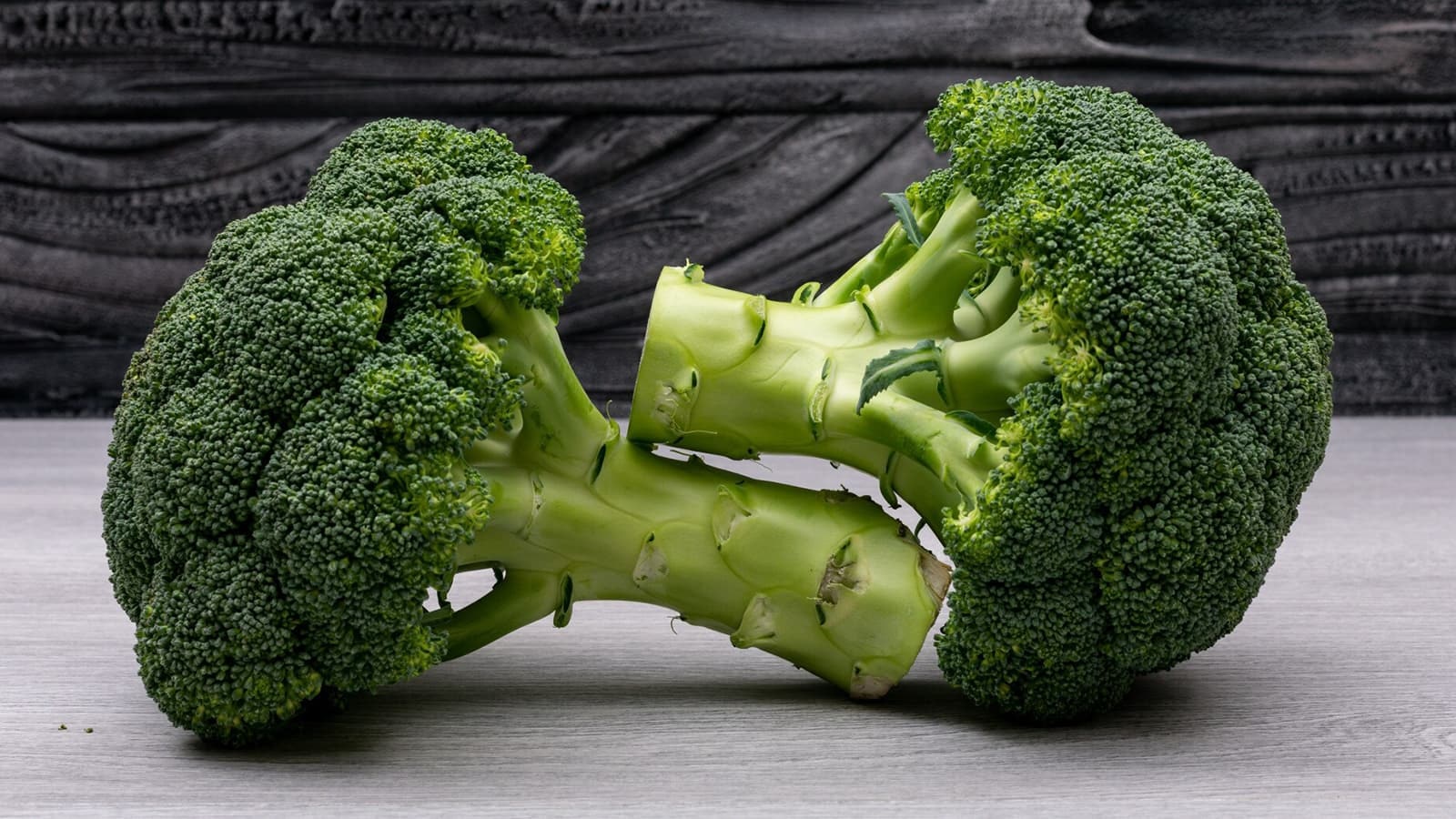 Wie gesund ist eigentlich Brokkoli? Bild von großem Brokkoli auf einem Holztisch.