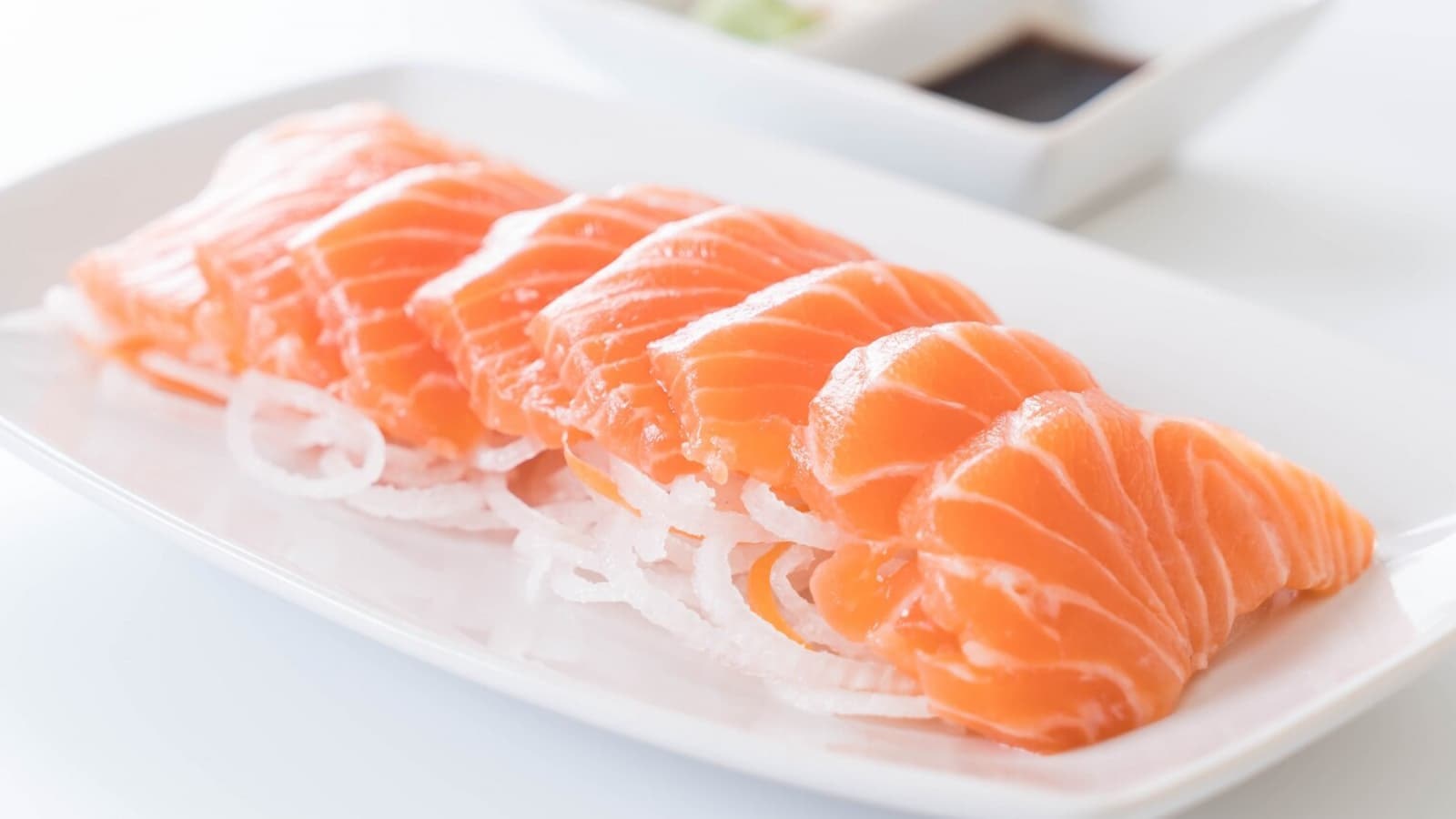 Wie gesund ist eigentlich Lachs? Bild von rohem Lachs auf einem weißen Teller.