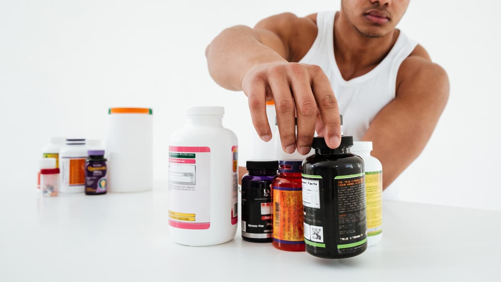 Sind BCAAs oder EAAs besser? Bild von einem Tisch voll mit Supplements zu denen BCAAs und EAAs gehören.