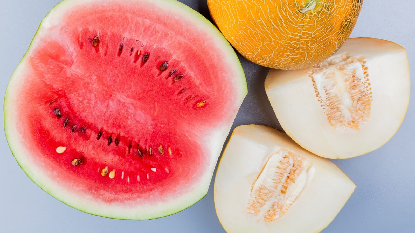 Wassermelone oder Honigmelone - Was ist besser? Bild von einer Wassermelone neben einer Honigmelone.