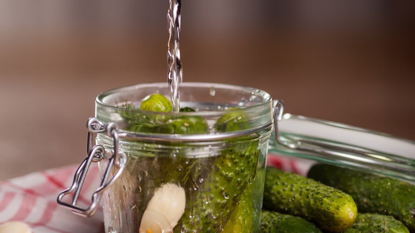 Gurkenwasser trinken - Was bringt das? Bild von einem Glas voll mit Gurken und Gurkenwasser.