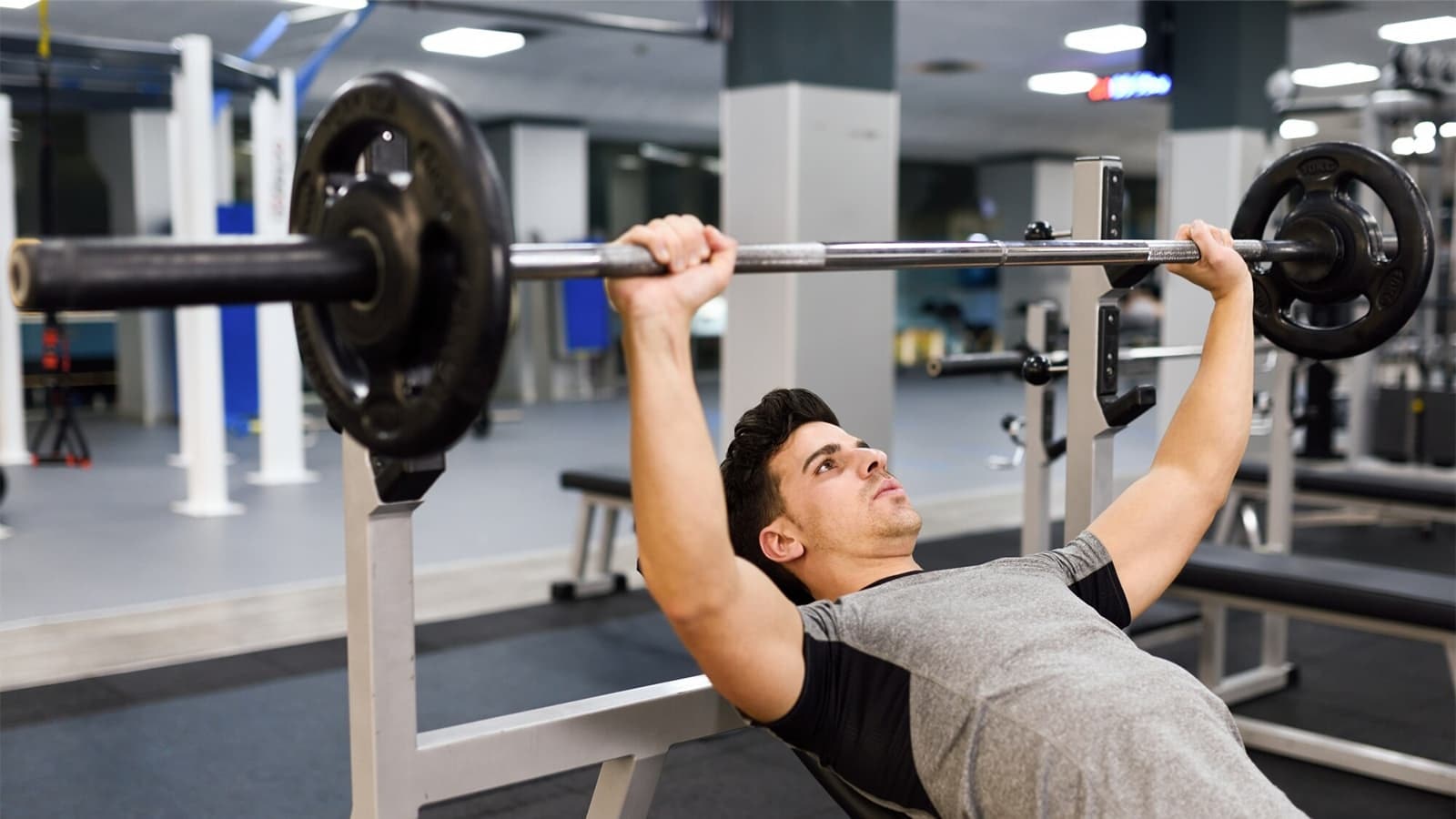 Ein Mann, der Bankdrücken im Gym macht.