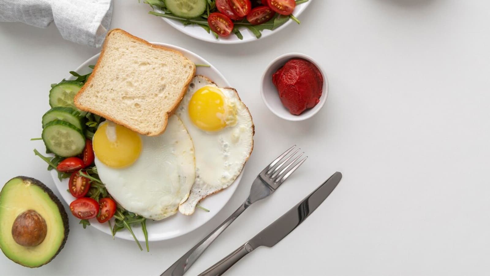 Ein Teller mit Eiern, Gemüse und Brot für ein gesundes Frühstück.