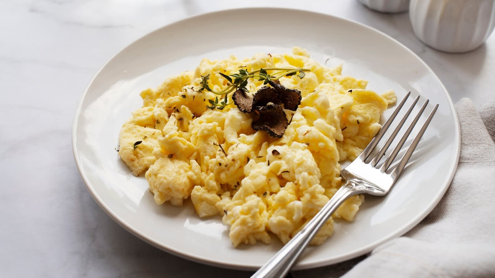 Ein Teller mit Rührei und Gewürzen für ein gesundes Frühstück.