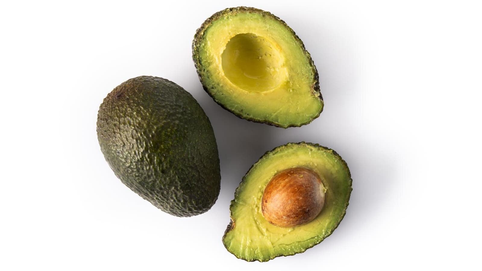 Halbierte Avocados auf einem weißen Boden.