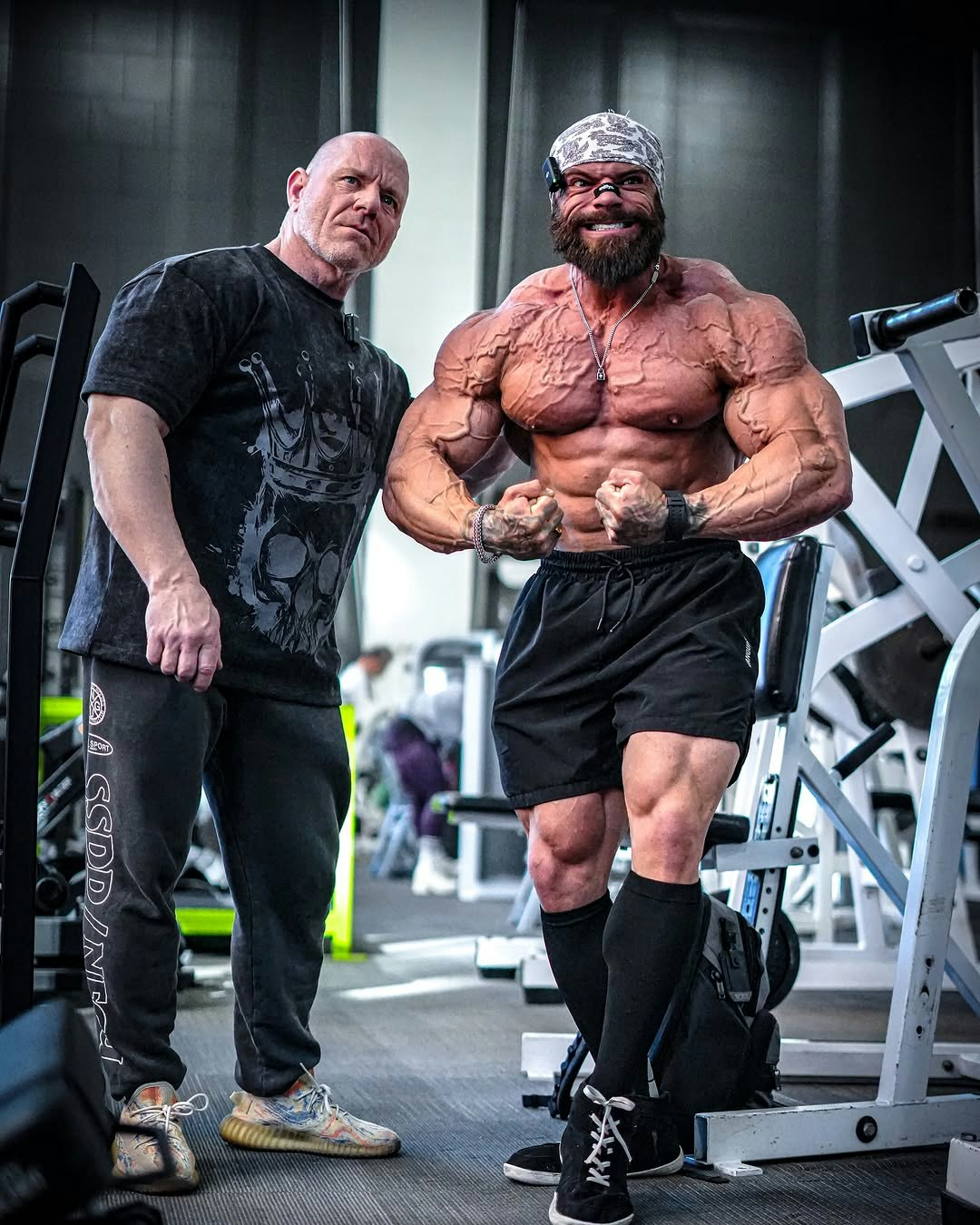 Mike Sommerfeld mit seinem Coach beim posen im Fitnessstudio.