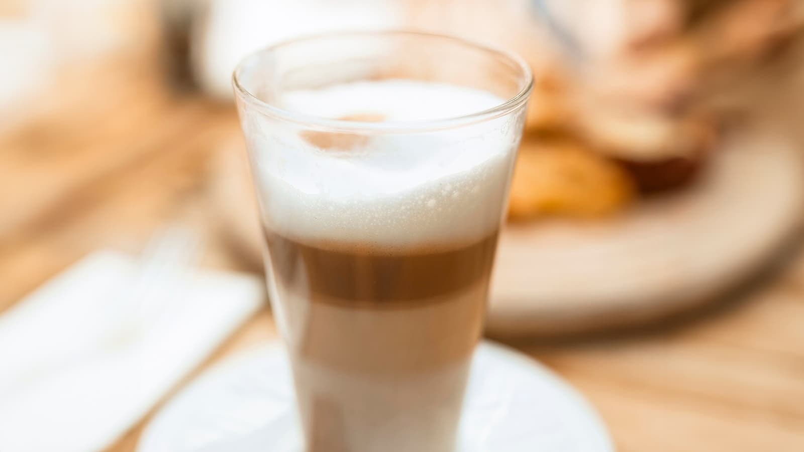 Bild von einem Latte Macchiato vor braunem Hintergrund.
