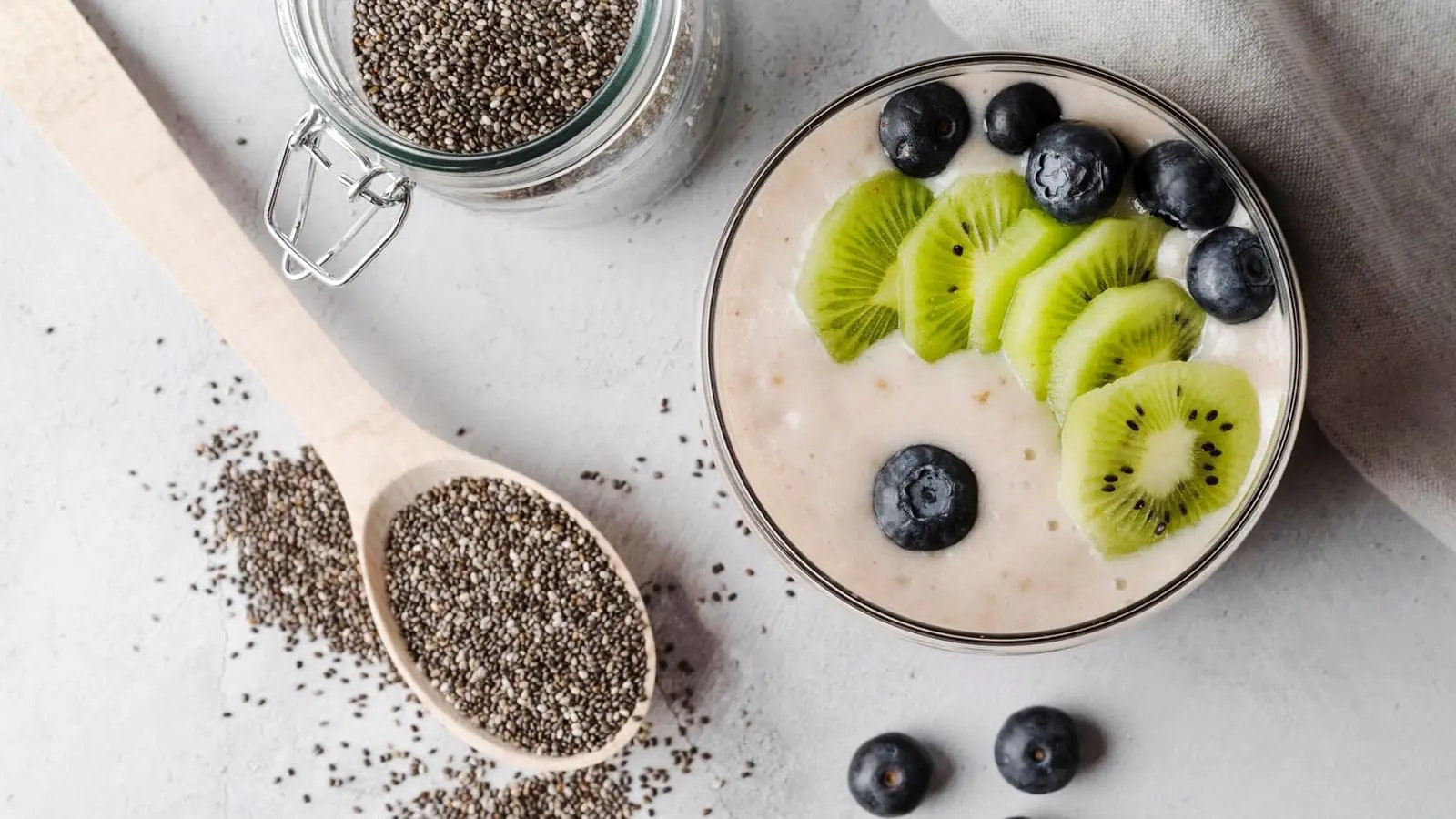 Chia Pudding mit Früchten und ein Glas voll mit Samen.