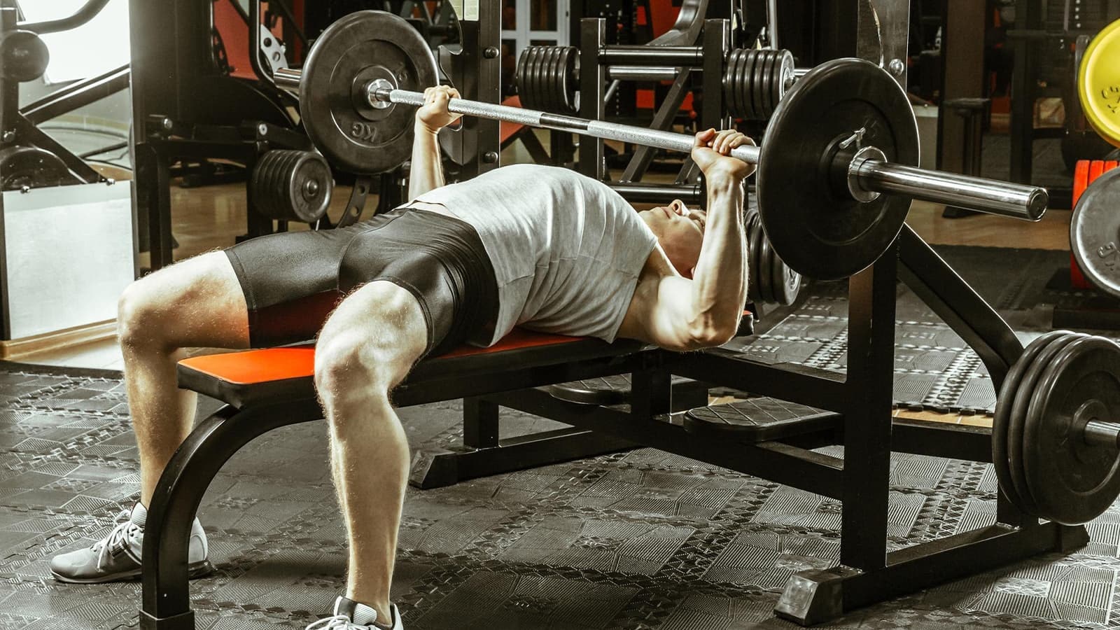 Ein Mann, der Bankdrücken im Gym macht.
